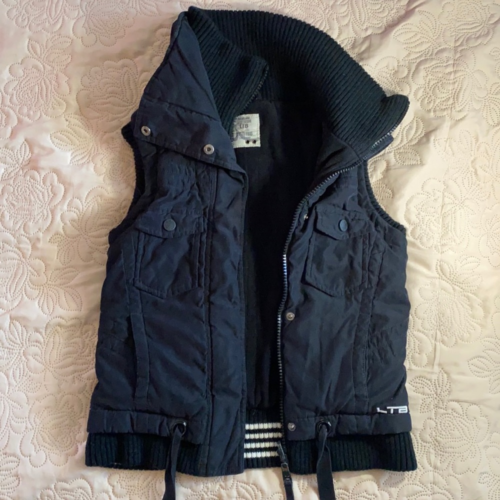 Sleeveless jacket with many pockets and high neck
